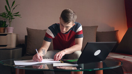 young man is doing distance learning at home using a computer. coronavirus isolation. close-up