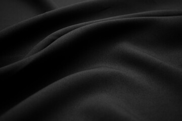 Texture of dark black fabric closeup. Low key photo. Plexus threads. Clothing industry. Abstract background. Black textile waves. Black cloth background