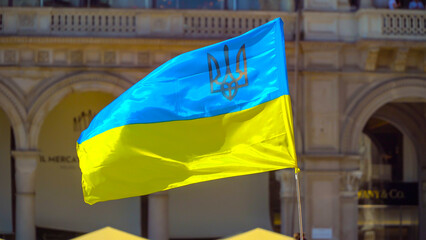 flag of Ukraine yellow and blue color flutters in the wind at a rally in the city. National flag...