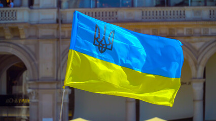 flag of Ukraine yellow and blue color flutters in the wind at a rally in the city. National flag and coat of arms of the country. Freedom. War and defense of a peaceful country