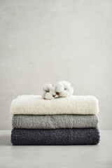 Fototapeta na wymiar Stack of bath towels with cotton flowers