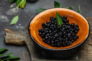 Wild berries, Northern berry: lingonberry, blueberry, Bowl of fresh maqui berry on dark background,...