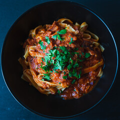 Pasta with tomato sauce in a black bowl