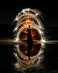 Woman posing for light painting with bright lights in the dark. Reflection in the water