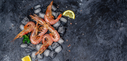shrimps. wild ocean jumbo shrimps with ice and lemon, seafood shrimps prawns on ice frozen. Long...