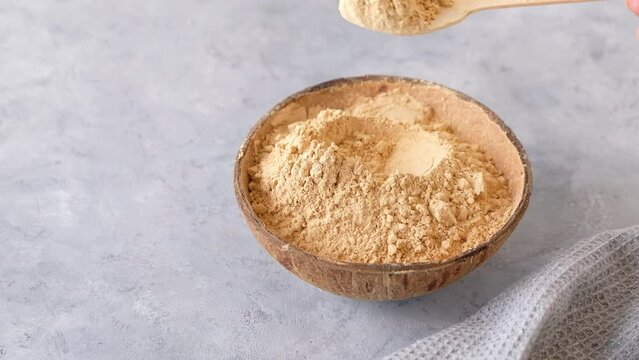 Woman's hand taking a spoon of maca root powder. Organic superfood. High quality 4k footage