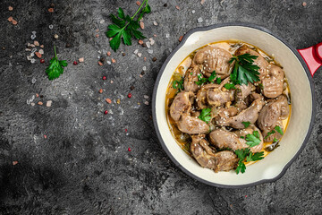 Raw chicken stomach, Traditional Korean spicy chicken gizzard with onions, garlic, chili and sesame on a gray background, place for text, top view