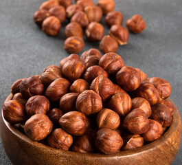 Top view of a bowl full of hazelnuts on dark background
