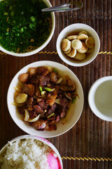 Top view of traditional Vietnamese meal with glazed pork belly, salted white eggplant and leaf mustard soup.