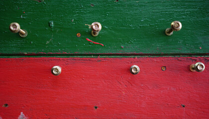 Screwers nailed on a red and green painted wood penal