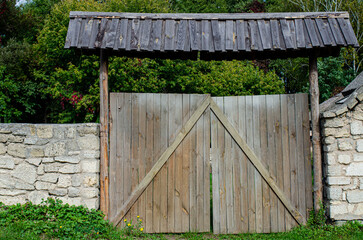Fototapeta premium old weathered door in the wooden wall of an ancient hut