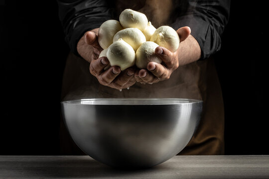 The homemade cheese maker produces handmade mozzarella with fresh bio milk. process of making mozzarella. Italian hard cheese silano or caciocavallo in cheesemaker hands