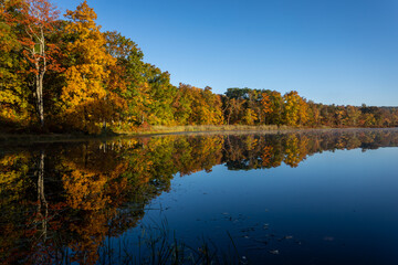 Sawmill Lake in High Point State Park, NJ, on a quiet and calm Autumn morning surrounded by brilliant fall foliage