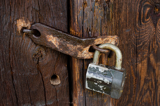Lock on an old wooden door with rusty inserts