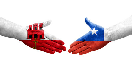 Handshake between Chile and Gibraltar flags painted on hands, isolated transparent image.