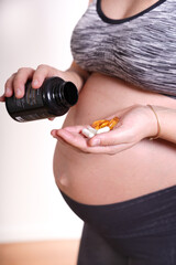beautiful 30s-40s pregnant woman taking health vitamin  pills