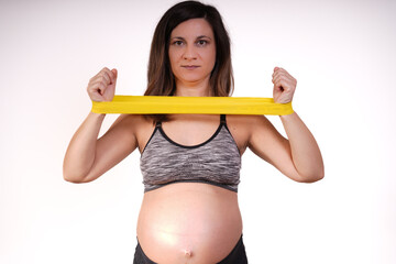 beautiful 30s-40s pregnant woman with exercise  Resistance Bands and doing fitness