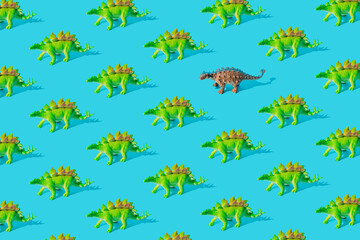 Green Stegosaurus and gray Ankylosaurus dinosaur toy on a blue background. Pattern.