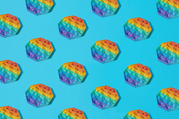 Obraz na płótnie Canvas Arranged colorful bubble rubber toy on a blue background. Pattern.