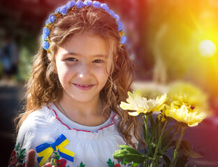 Ukrainian Schoolgirl in a wreath and embroidered shirt and with patriotic flowers against the war in Ukraine - 538408018