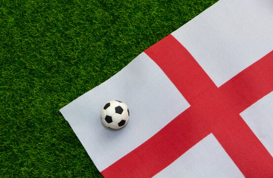 Football and Englad Flag on Green Field