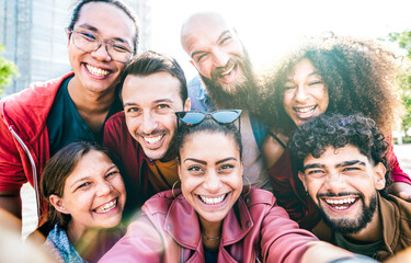Obraz premium Multicultural friends taking selfie outdoors - Happy millenial friendship concept on young multiracial people having fun together