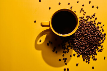 Cup of freshly brewed roasted coffee beans on yellow background