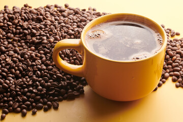 Cup of freshly brewed roasted coffee beans on yellow background