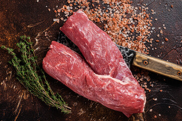 Uncooked lamb loin fillet, Mutton raw meat on butcher cleaver. Dark background. Top view