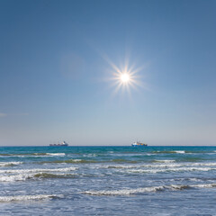 sea coast with cargi ship at the storm, sea scape at sunny day