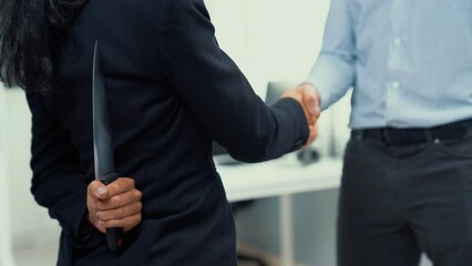 Back view of businesswoman shaking hands with another businessman while holding a knife behind his back. Concept of back backstabbing in business, backstabbing between colleagues.