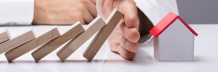 Human Hand Stopping The Wooden Blocks From Falling