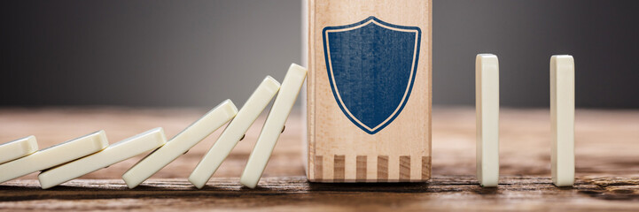 Block With Shield Symbol Amidst Falling Domino Pieces