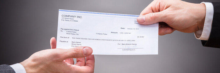 Businessperson Giving Cheque To Colleague