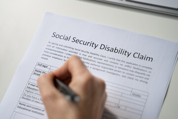 Close-up Of Person Hand Filling Social Security Benefits