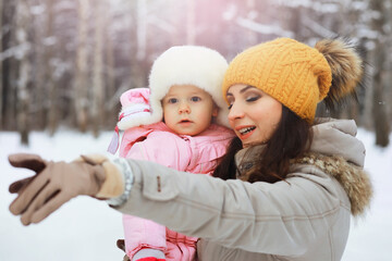 Obraz premium Happy family playing and laughing in winter outdoors in the snow. City park winter day.