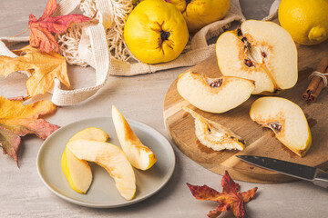 Ripe whole and sliced quinces. Fresh fruit for preparing recipes with cinnamon and lemon. An essential ingredient for a healthy diet