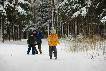 Happy family playing and laughing in winter outdoors in the snow. City park winter day.