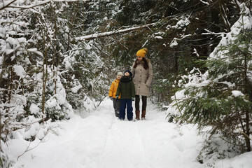 Happy family playing and laughing in winter outdoors in the snow. City park winter day.