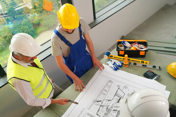 Architect and construction engineer or surveyor discussion plans and blueprints