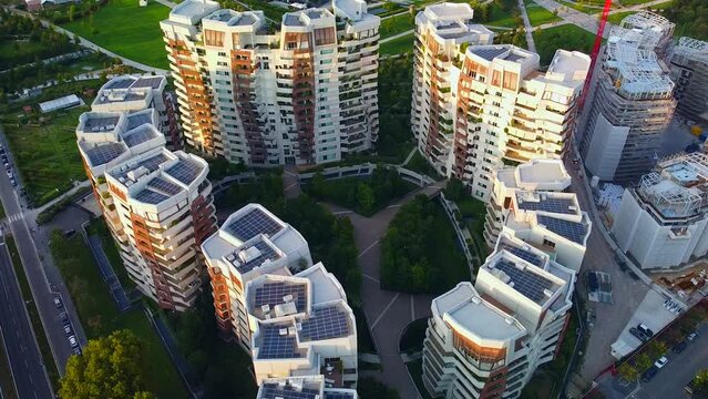 Glass buildings in Europe City Life. Aerial view of modern architecture of office buildings in new city districts. Night city lights. the drone shoots at three towers. Milan, Italy, September 2022