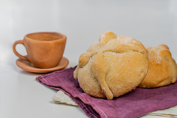 Traditional  mexican bread of the dead and cup of coffee on white table