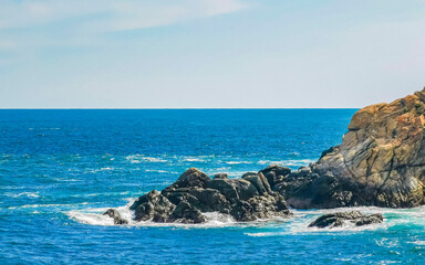 Fototapeta na wymiar Beautiful surfer waves rocks cliffs at beach Puerto Escondido Mexico.