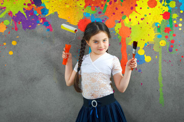 cheerful smiling young little girl the child draws on the background wall colored paints making a creative repairs