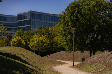 Fototapeta premium Beautiful s-shape path in park with trees and buildings