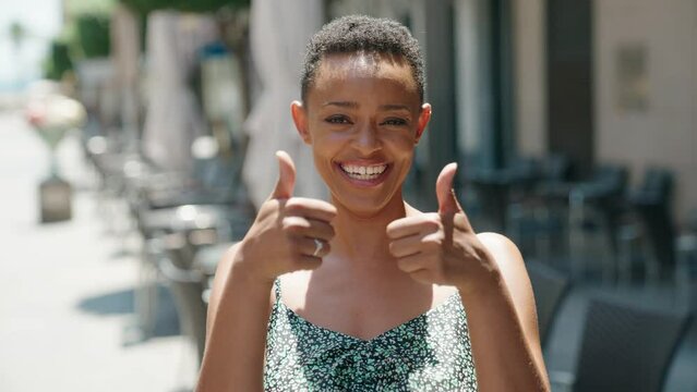 African american woman smiling confident doing ok sign with thumbs up at street