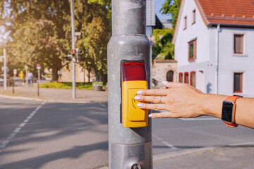 Aware passenger presses the traffic light control button to safely cross the street. Accident...