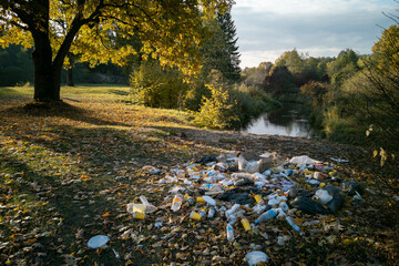 Garbage pile in forest. Rubbish heap after picnic near river. Environmental pollution. Ecological...