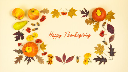 Happy Thanksgiving. Greeting card. Beautiful frame of autumn leaves, orange pumpkins, ripe apples, pears, rowan berries and acorns.