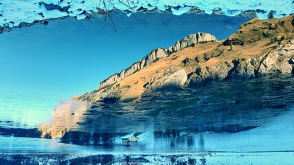 Ziesler Berg und Ebenalp spiegeln sich in vereistem Seealpsee im Schweizer Alpstein Gebirge